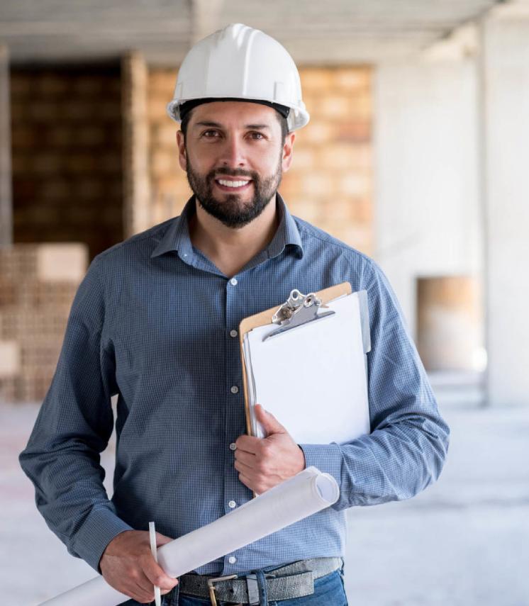 Portrait of an engineer holding a blueprint at a construction site